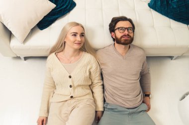 Sevimli, beyaz, sarışın, uzun saçlı, esmer, sakallı ortağıyla yere uzanmış geleceğe bakıyor.