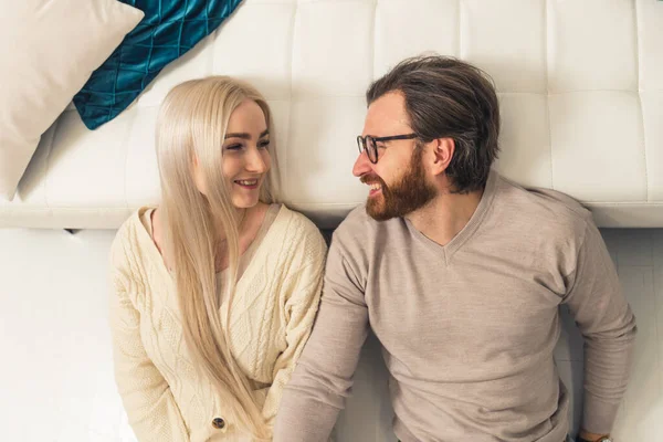 Belle couple de conjoints caucasiens couché et regardant l'autre avec un sourire sur leurs visages — Photo