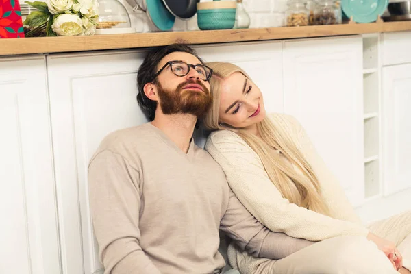 Millennial casal caucasiano sentado no chão cozinhas, ligação, abraço, e contemplando — Fotografia de Stock