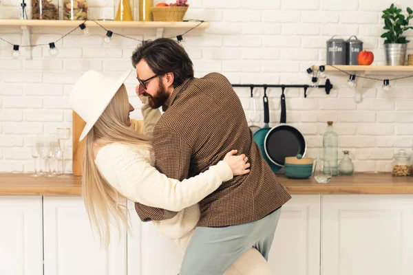 Одружена кавказька пара святкує і танцює в їхній сучасній яскравій кухні. — стокове фото