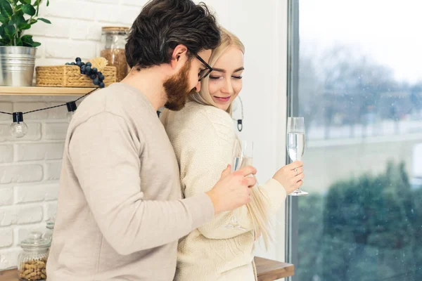 Красивая кавказская длинноволосая девушка флиртует со своим новым парнем, держа в руках белые бокалы для вина среднего размера — стоковое фото