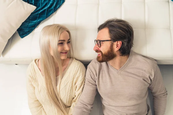 Européenne blonde aux cheveux longs femme couchée avec son petit ami barbu brunet et souriant — Photo