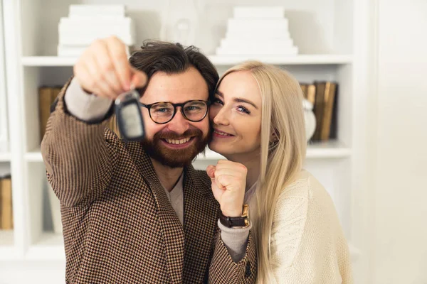 Grijnzend Kaukasisch paar met sleutels van hun nieuwe auto. — Stockfoto