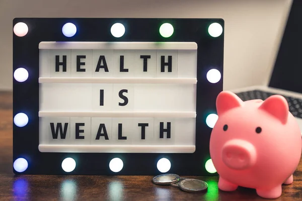 Health is Wealth phrase spelled on marquee lightbox - savings in medical care concept