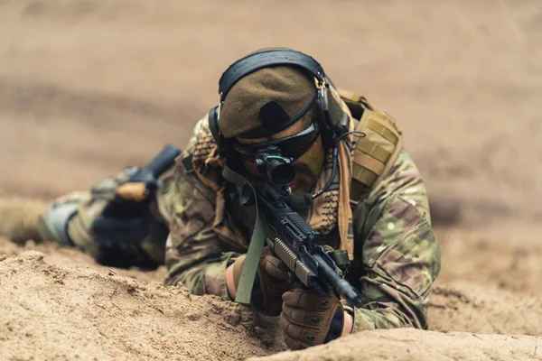 Marin soldat i MTP uniform uniform liggande på sanden och siktar på målet — Stockfoto