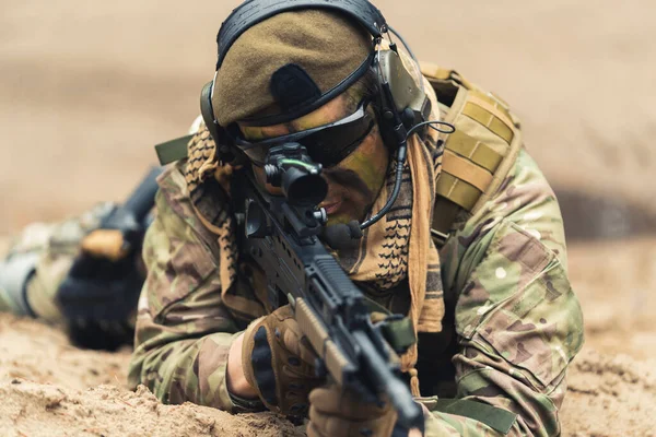 Focused soldier at ground level stance aiming using target scoop — Stock Photo, Image