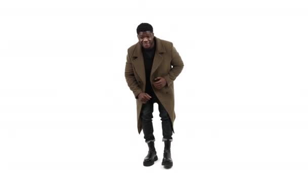 Elegante hombre africano vistiendo abrigo de invierno y bailando divertido - aislado en el espacio de copia de fondo blanco — Vídeos de Stock