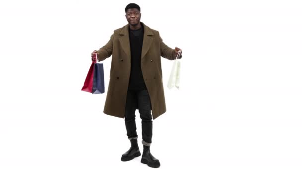 Hombre negro comprador con bolsas en las manos fondo blanco - full shot — Vídeos de Stock