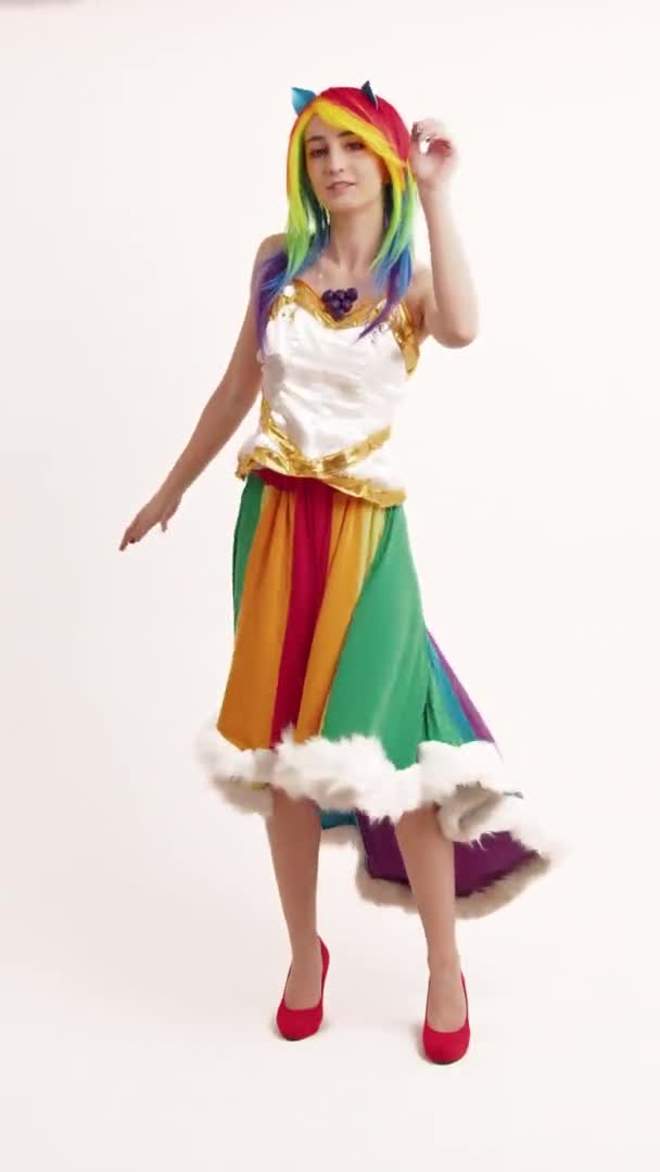 Vertical Shot Flirty Молодой кавказский носить экстравагантную радугу Одежда Танцует белый фон — стоковое видео