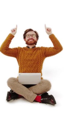 dikey stüdyo, sırıtan bir adamın işaret parmaklarıyla yukarı bakıp, beyaz arkaplanı kopyalamasını çeker.