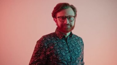 Sakallı, orta yaşlı, beyaz iş adamı kameraya bakıp başını sallayarak onaylıyor.