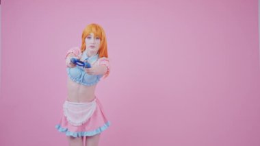 Fit Gamer Girl, VR ve Gamepad kullanarak Eşleriyle Savaşıyor. Pembe arka plan, orta boy stüdyo fotoğrafı.