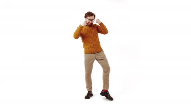 Mutlu milenyum adamı bir elinde telefonuyla dans eder izole edilmiş beyaz arka plan stüdyo çekimi — Stok video