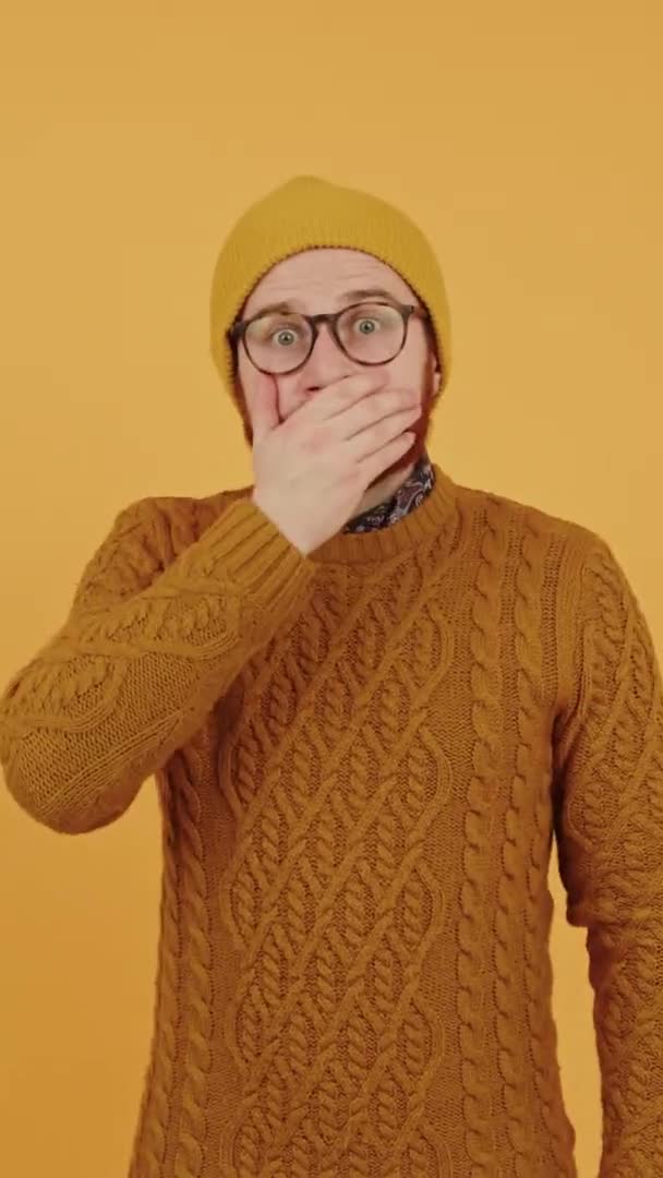 Şaşırmış Kafkas sakallı orta yaşlı bir adam ağzını sağ avuç içi dikey stüdyo fotoğrafıyla sarıya boyamış. — Stok video