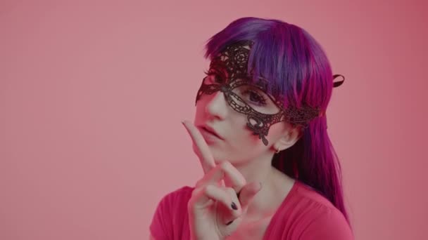 Flirtig sexig kaukasiska kvinna vidrör sina läppar med ett finger och lugnar någon medium närbild skott rosa bakgrund — Stockvideo