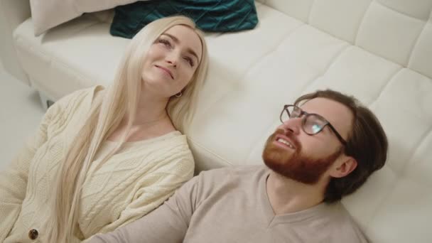 Europeisk blond långhårig kvinna som ligger med sin brunett skäggiga pojkvän och ler — Stockvideo