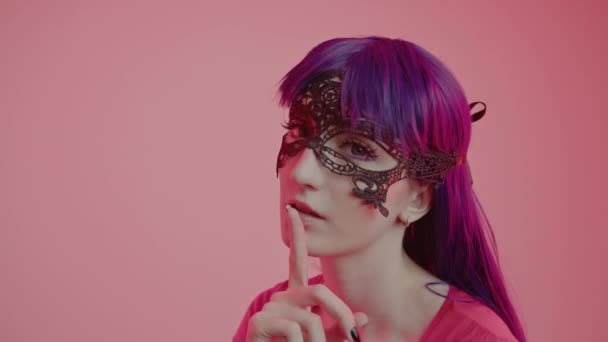 Mujer caucásica joven seductora en una máscara de encaje silenciando y mirando a su alrededor plano medio — Vídeos de Stock