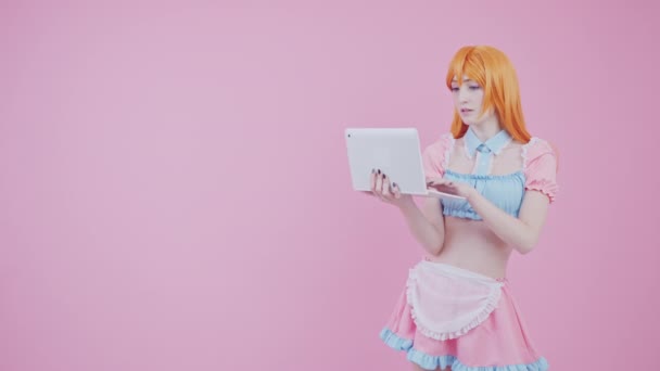 漂亮的白人女孩在网上搜索信息和发送电子邮件中长工作室拍摄粉红背景 — 图库视频影像