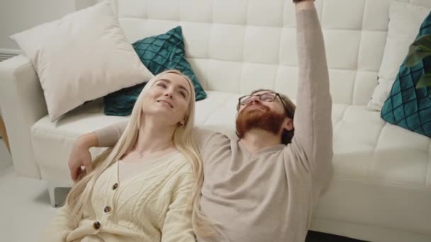 バレンタインデーを祝うコンテンツ白人夫婦が床に横たわり見上げ笑顔で — ストック動画