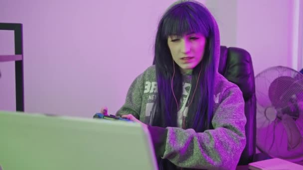 20 'li yaşlarda beyaz bir kız inatla bir bilgisayar oyunu kazanmaya çalışıyor. — Stok video