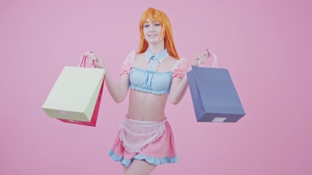 Söt kaukasisk shopaholic tonåring poserar med påsar fulla av varor köpta på försäljning medium lång studio skott — Stockvideo