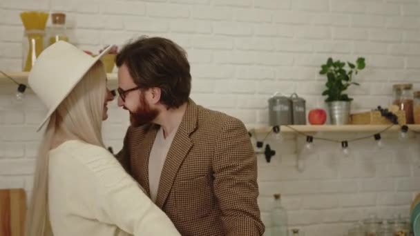 Porträtt av ung europeisk man som dansar med sin vackra långhåriga fru i köket och firar sin årsdag — Stockvideo