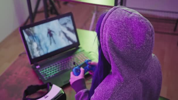 Bastante morena en una sudadera con capucha jugando juegos de ordenador con Gamepad Medio Primer plano — Vídeo de stock