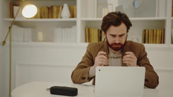 Jovem empresário preocupado trabalhando e olhando seriamente para a tela de seu laptop — Vídeo de Stock