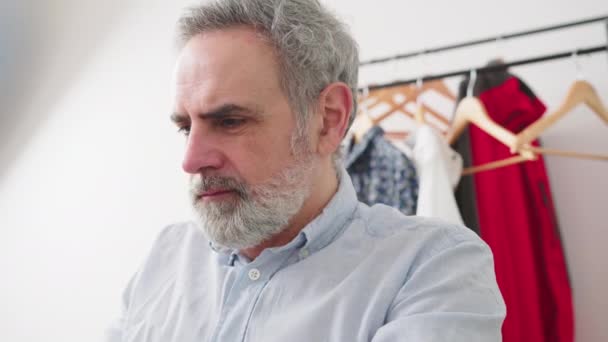 Homem barbudo de cabelos grisalhos satisfeito que trabalha no computador em seu quarto - tiro de perto — Vídeo de Stock