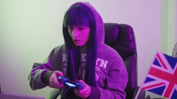 白人ゲーマーは、英国のメディアのクローズアップショットで新しいコンピュータゲームに勝つために彼女のチャンスを取って — ストック動画