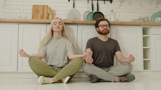 Lyckliga kaukasiska par mediterar på karantän i sin moderna lägenhet, ta hand om fysisk och psykisk hälsa — Stockvideo