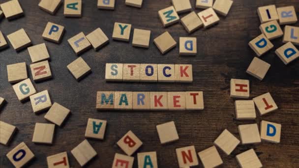 Palabras del mercado de valores escritas a partir de letras de bloques de madera - zoom en tiro — Vídeo de stock