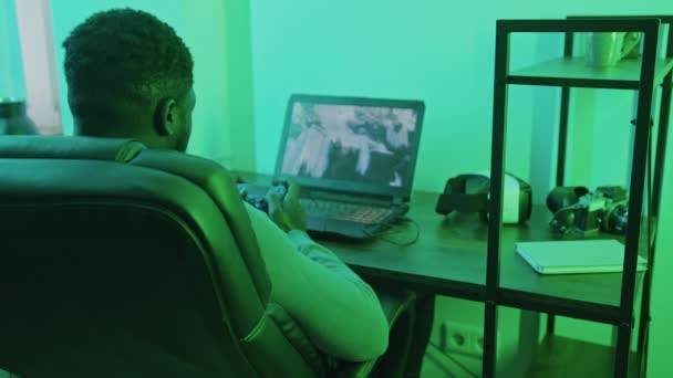 Bilgisayar oyun platformunda oynayan Afroamerikalı bir adam. Omzundan vurulmuş. — Stok video
