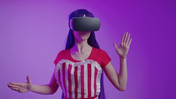 Felice giovane donna caucasica utilizzando un auricolare realtà virtuale medio studio girato sfondo magenta — Video Stock