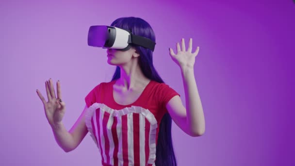 Студійний знімок кавказької дівчини-гравця в гарнітурі vr, граючи у гру віртуальної реальності з враженим виразом обличчя — стокове відео