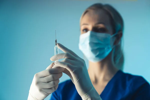 Vrouwelijke arts in de kliniek bereidt verdoving voor de patiënt. Esthetische geneeskunde concept. Medium close-up studio opname. — Stockfoto
