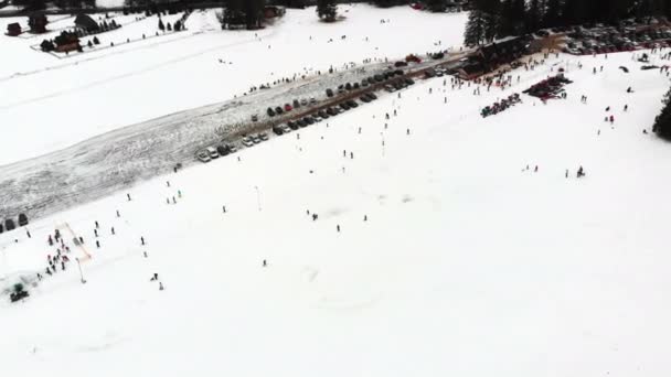 Přeplněná sjezdovka. Mnoho lidí lyžování a snowboarding během zimních prázdnin. Letecký pohled. — Stock video