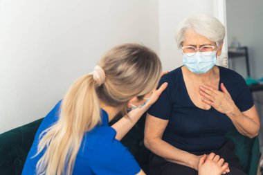 Yaşlı beyaz kadın, kadın doktora sağlık sorunlarından şikayetçi.. 