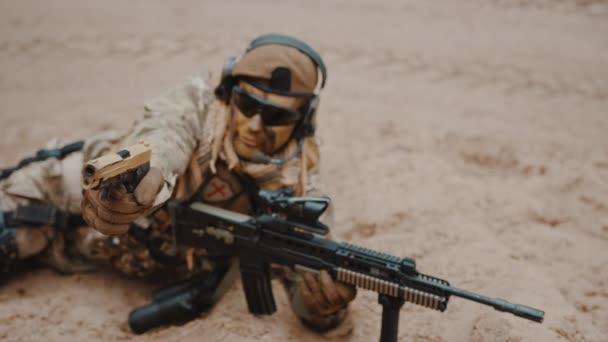 Żołnierz morski celujący z pistoletu leżącego na piasku - koncepcja wojny — Wideo stockowe