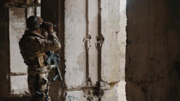 Солдат, использующий бинокль для обнаружения врагов во время военной операции на Украине — стоковое видео