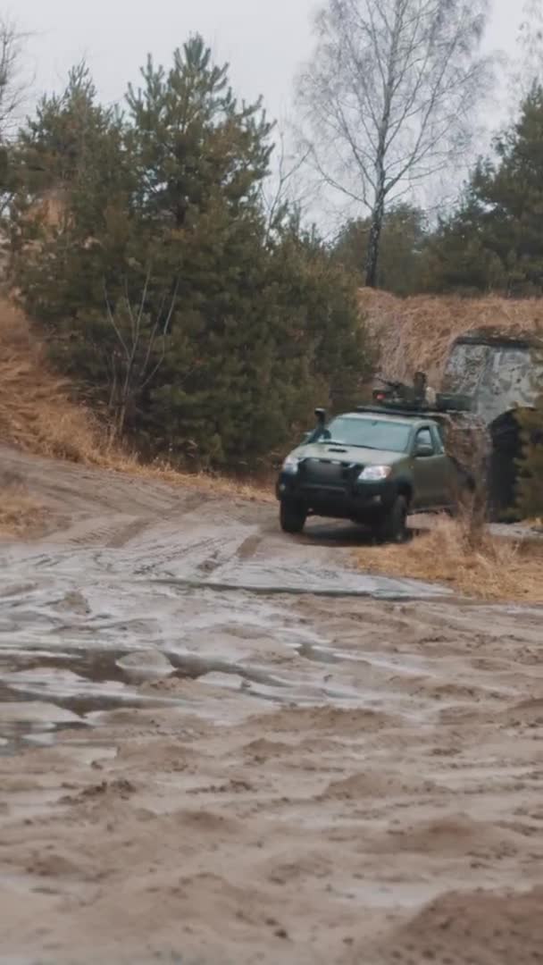 Tiro vertical - Engrenagens de caminhões de patrulha militares pesados ficando sujos na poça de lama em uma faixa transversal — Vídeo de Stock