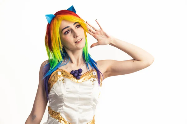 Modernly-looking youthful girl with rainbow hair happily reaching out towards the camera medium studio shot — Stock Photo, Image