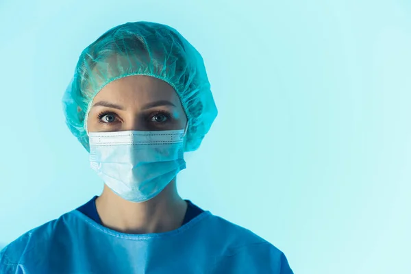 Cirurgião Feminino Usando máscara protetora e retrato de terno protetor no fundo azul — Fotografia de Stock