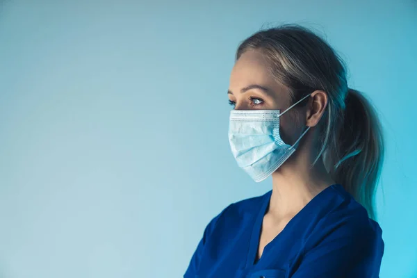 Europese vrouw verpleegster in haar dertiger jaren observeren chirurgie terwijl het dragen van gezichtsmasker die haar mond en neus bedekt. — Stockfoto