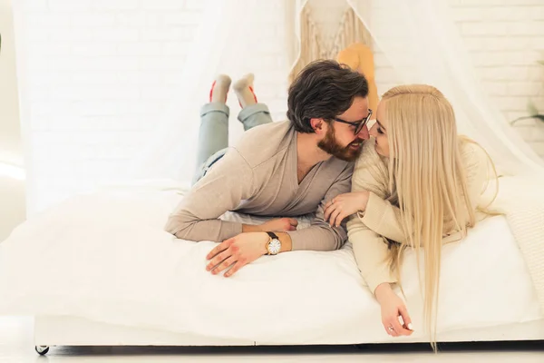 Doce caucasiano casal deitado na cama juntos enquanto tocando seus narizes em sinal de afeto — Fotografia de Stock