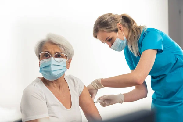 Responsable caucásico señora mayor recibiendo una vacuna jab. — Foto de Stock