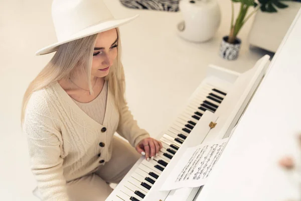 Jeune femme blonde caucasienne en vêtements légers jouant de l'espace de copie de piano — Photo