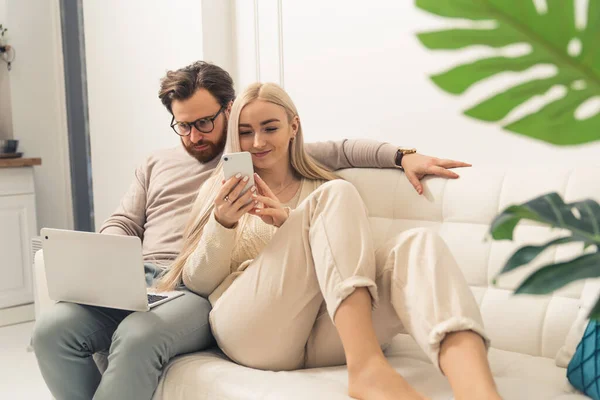 Jong blank paar werken op de bank met gadgets afgelegen baan — Stockfoto