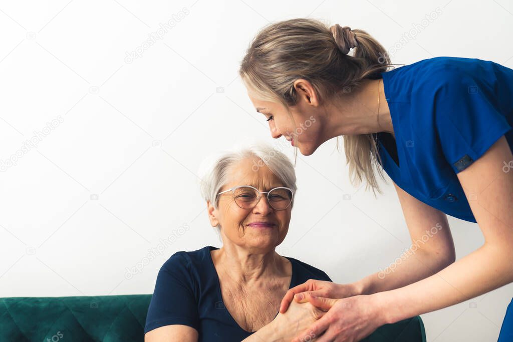 Nursing lady at her elderly retired patients home. Healthcare concept.