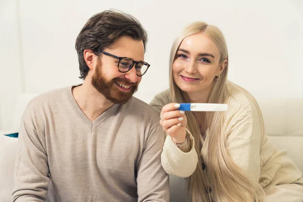 Nadšený mladý kavkazský pár těhotná žena ukazující pozitivní těhotenský test na fotoaparátu portrét — Stock fotografie